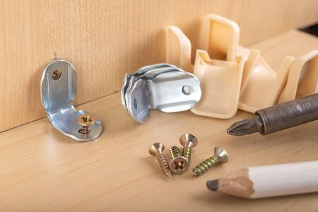 Mounting connectors installed to the chipboard. Carpentry work during the construction and assembly of furniture. Dark background.の写真素材