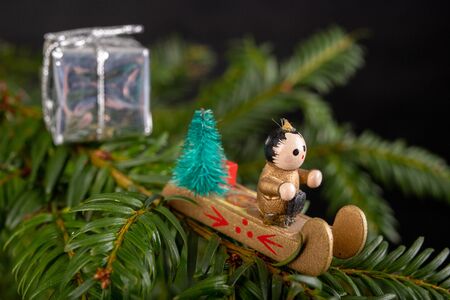 Christmas decorations on the green tree. Tinsels hung on a spruce twig. Dark background.