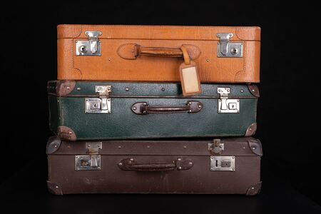 Old destroyed suitcases. Trunks used during long journeys. Dark background.