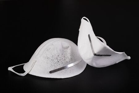 White dust mask. Respiratory protection at the workplace. Dark background.の写真素材