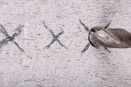 Drilling a hole in the wall. Construction works in the apartment. Light background.