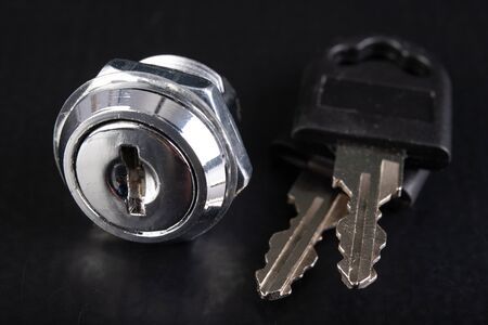 Small lock for the metal cabinet and keys. Accessories for securing private property. Dark...