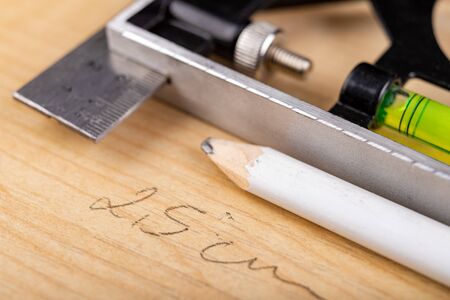 Designation of cutting places on chipboard. Measuring instruments used in carpentry. Light background.の写真素材