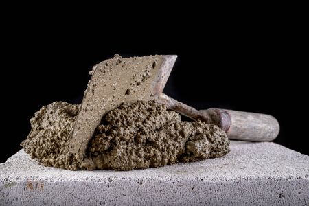 Trowel and mortar prepared for masonry. Accessories for building houses. Dark background.の写真素材