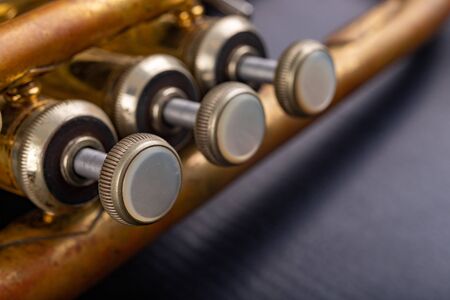 Details of an old patina covered trumpet. Musical instrument shown in magnification. Dark background.の写真素材