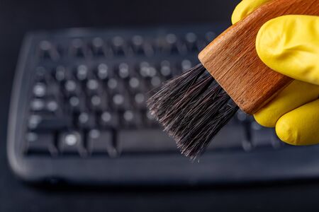 Cleaning the keyboard from dust and dirt with a brush. Maintenance and cleaning of computer...