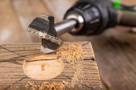 Drilling in raw wood. Drill bit for large holes. Place - carpentry workshop.の写真素材