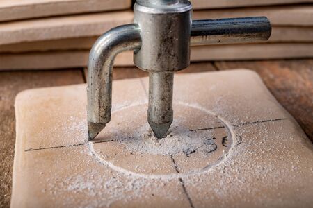 Drilling with a special drill in a ceramic tile. Tiling works during renovation. Workplace - workshop.の写真素材
