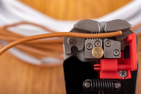 Removing protective insulation from electrical wires. Small work in the home workshop. Light...
