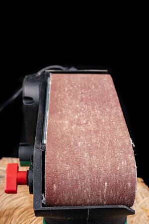 A belt sander for wood. Accessories for small carpentry work. Dark background.の写真素材