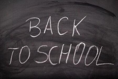 The inscription back to school on the school blackboard. White letters on a black background in the...