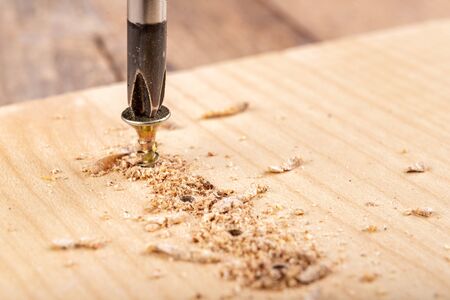 Screwing metal screws into chipboard for furniture construction. Small carpentry work in the home...