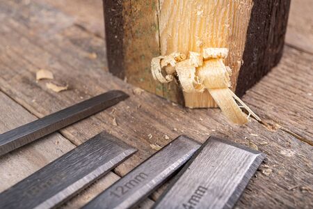 Work with a carpenter's chisel in pine wood. Small carpentry work in the home workshop. Light...