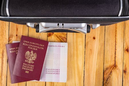 Large travel suitcase and Polish passport. Packed luggage prepared for travel abroad. Dark background.の写真素材