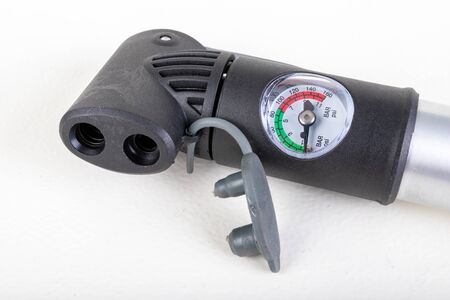 Small bicycle pump. Device for inflating wheels on a bicycle. Light background.