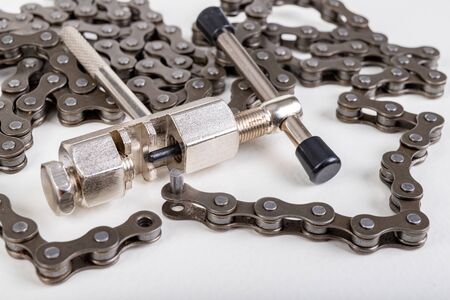 Repair of the bicycle chain in the workshop. Minor repair work at home. Light background.