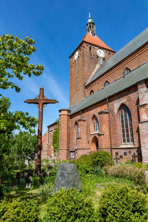 Darlowo, zachodniopomorskie / Poland - June, 4, 2020: Catholic temple in a small town in Pomerania. Old red brick building. Spring season.のeditorial素材