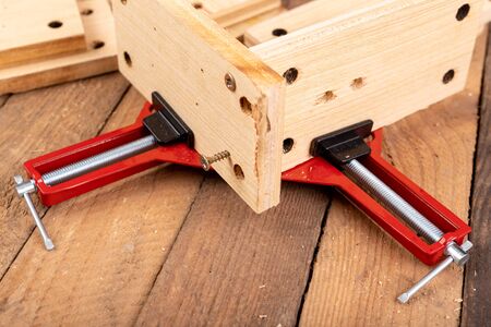 Joining wood using a carpentry clamp. Small carpentry work. Workplace - workshop.