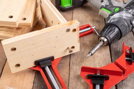 Joining wood using a carpentry clamp. Small carpentry work. Workplace - workshop.の写真素材