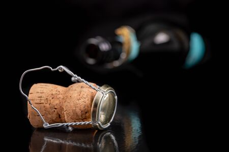Champagne cork on a dark table. Metal basket and bottle stopper with alcoholic liquor. Black background.の写真素材