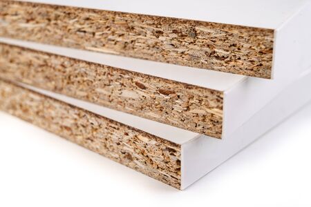 Pieces of white chipboard stacked. Material for the construction of furniture in the carpentry shop. Workplace workshop.の写真素材
