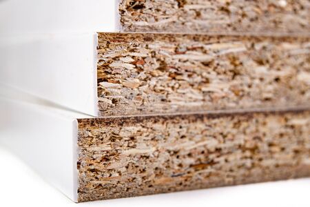 Pieces of white chipboard stacked. Material for the construction of furniture in the carpentry shop. Workplace workshop.の写真素材