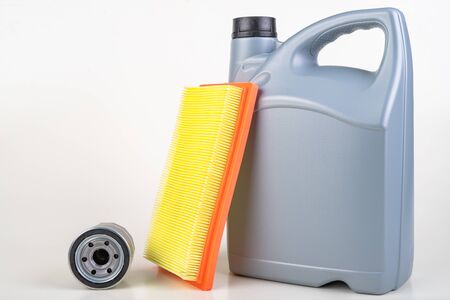 Filters and a container with oil for a passenger car. Maintenance accessories for vehicles for private use. Light background.の写真素材