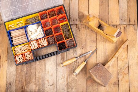 Carpentry tools on a wooden table. Utensils in a box for joining wood. Place - home workshop.の写真素材