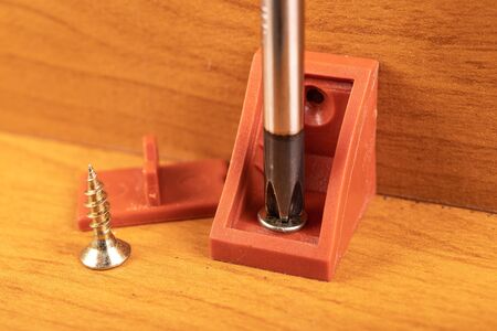 Plastic brackets for connecting chipboard. Small carpentry work in the workshop. Work place - carpentry shop.の写真素材