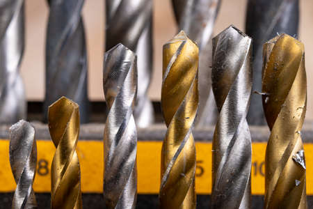 Metal drill bits placed in a stand. Accessories in a home workshop. Workplace garage at home.の写真素材