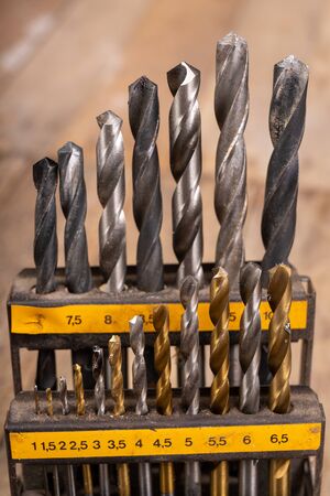 Metal drill bits placed in a stand. Accessories in a home workshop. Workplace garage at home.の写真素材