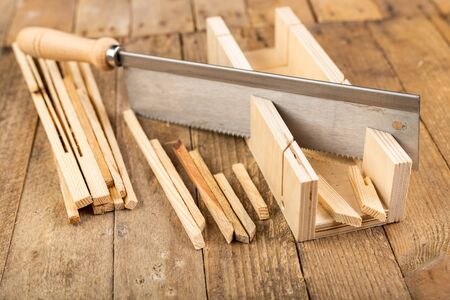Cutting wooden slats at an angle. Small works in the carpentry shop. Workplace home workshop.の写真素材