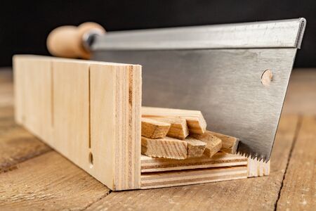 Cutting wooden slats at an angle. Small works in the carpentry shop. Workplace home workshop.の写真素材