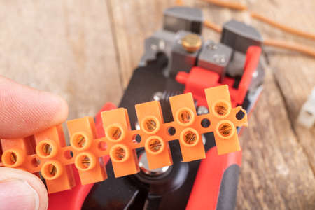 Trimming a copper electric wire. Scissors for electrical work. Light background.