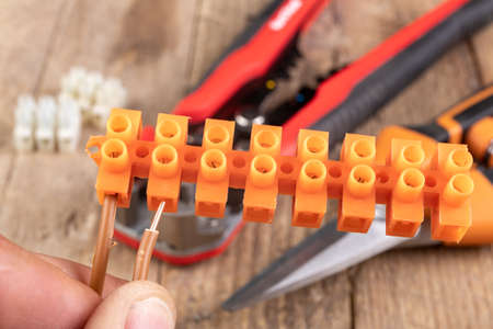 Trimming a copper electric wire. Scissors for electrical work. Light background.の写真素材