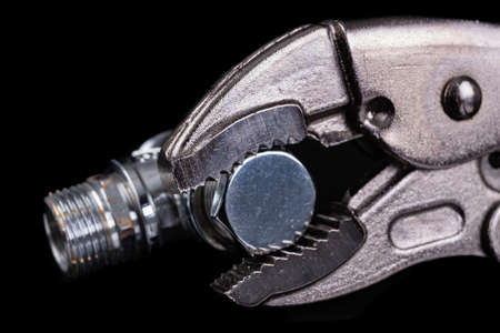 Silver plumbing wrench and chrome pipe. Plumbing accessories for minor repairs at home. Dark...