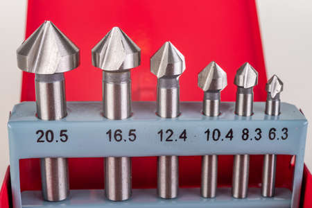 Countersinks for performing phases in various materials. Tools used in industry. Light background.