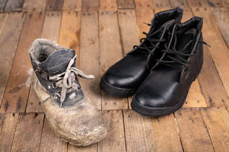 Old work shoe. New work shoes for production workers. Dark background.