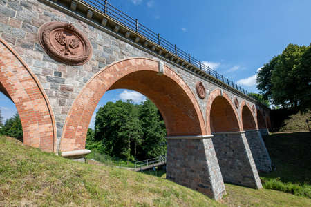 Bytow, pomorskie / Poland - July, 17, 2020: Old bridge built of stones and bricks. Railway crossing over a small river. Summer season.のeditorial素材