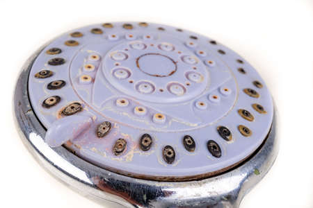Old dirty shower head. Strong dirt in the home bathroom. Light background.の写真素材