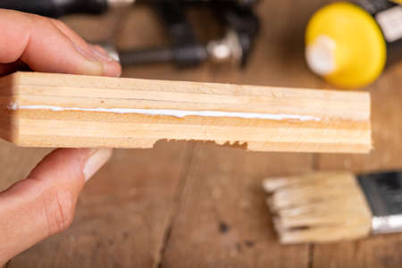 Gluing wood with carpentry glue. Minor carpentry work in a home workshop. Light background.の写真素材