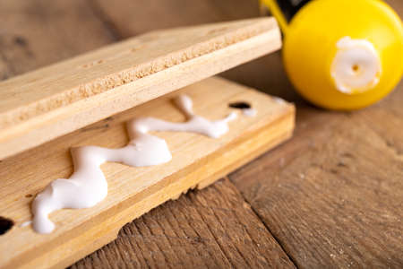 Gluing wood with carpentry glue. Minor carpentry work in a home workshop. Light background.の写真素材