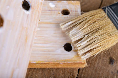 Gluing wood with carpentry glue. Minor carpentry work in a home workshop. Light background.の写真素材