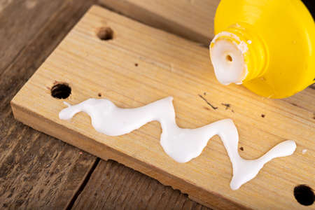 Gluing wood with carpentry glue. Minor carpentry work in a home workshop. Light background.の写真素材
