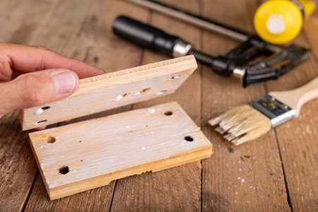 Gluing wood with carpentry glue. Minor carpentry work in a home workshop. Light background.の写真素材