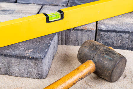 Laying paving stones on sand. Minor paving work in a home environment. Garden workplace.の写真素材