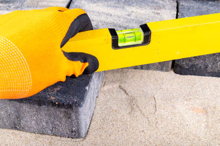 Laying paving stones on sand. Minor paving work in a home environment. Garden workplace.の写真素材