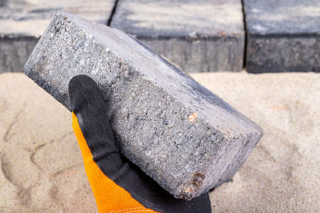 Laying paving stones on sand. Minor paving work in a home environment. Garden workplace.の写真素材