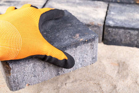 Laying paving stones on sand. Minor paving work in a home environment. Garden workplace.の写真素材