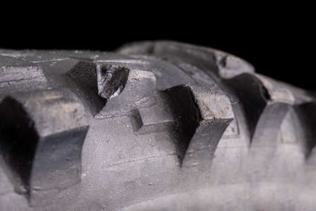 Damaged tread in a motocross tire. Damaged tire with high tread. Dark background.の写真素材
